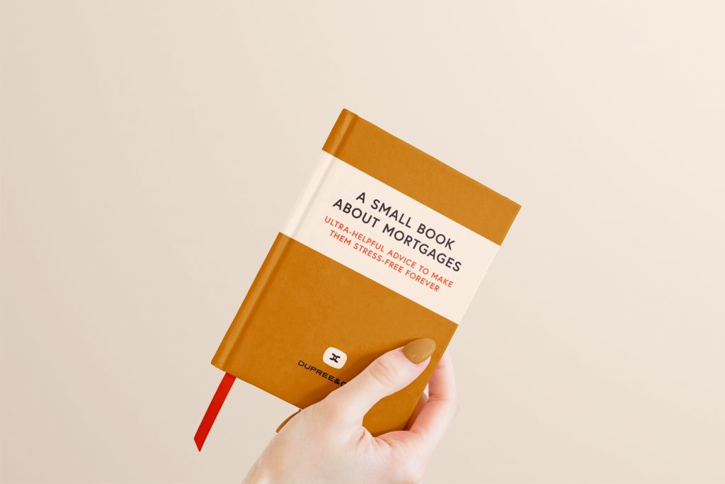 A mockup of hand holding a small book