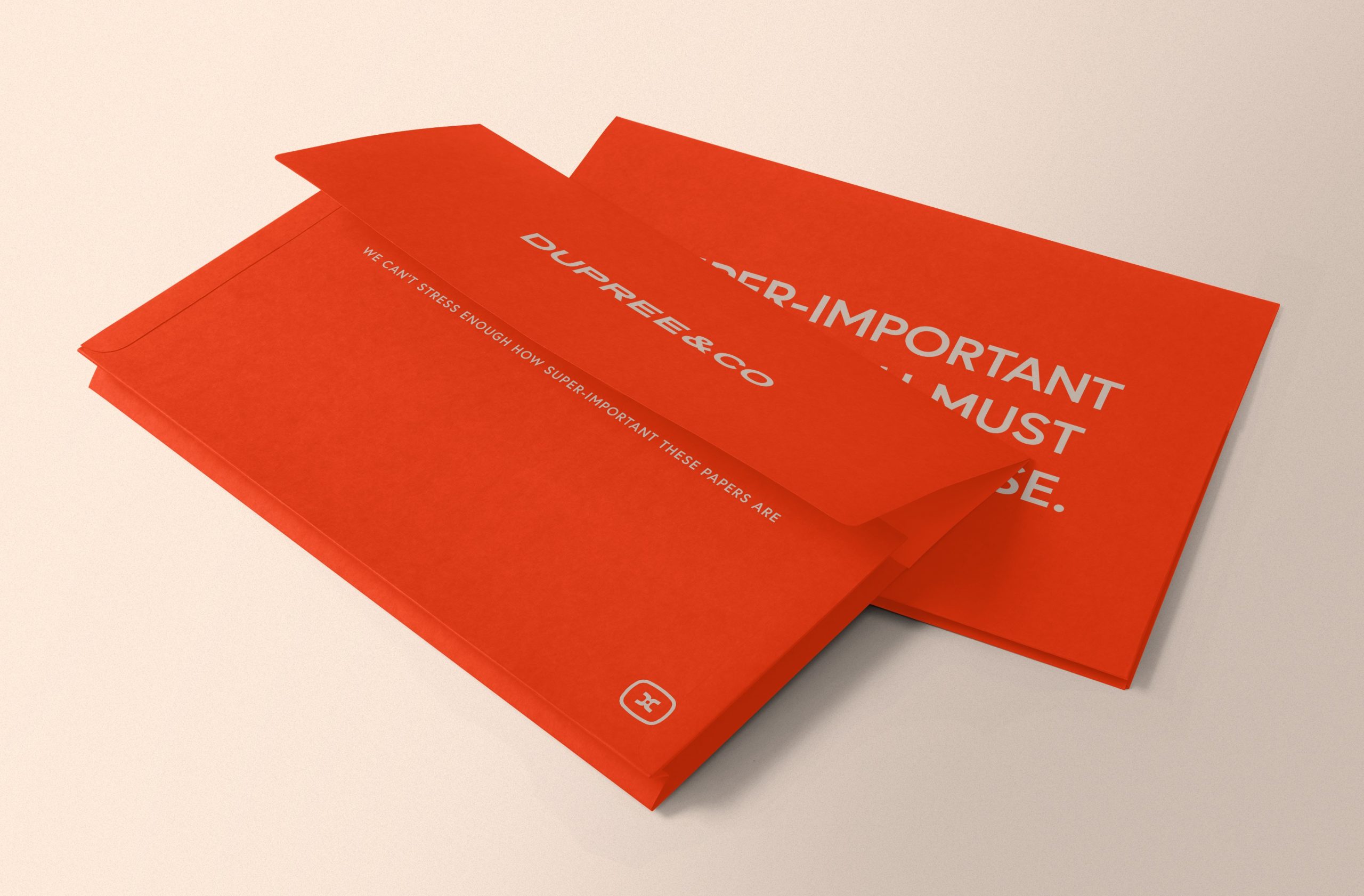 Two orange folders laid on a surface one on top of the other